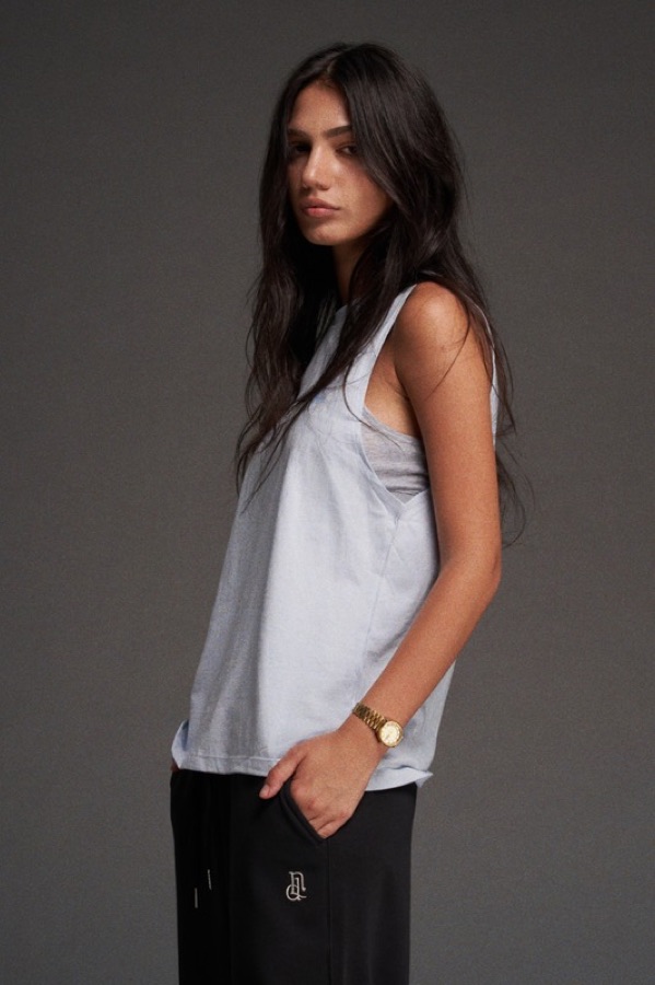 Woman in a white tank top and sweatpants